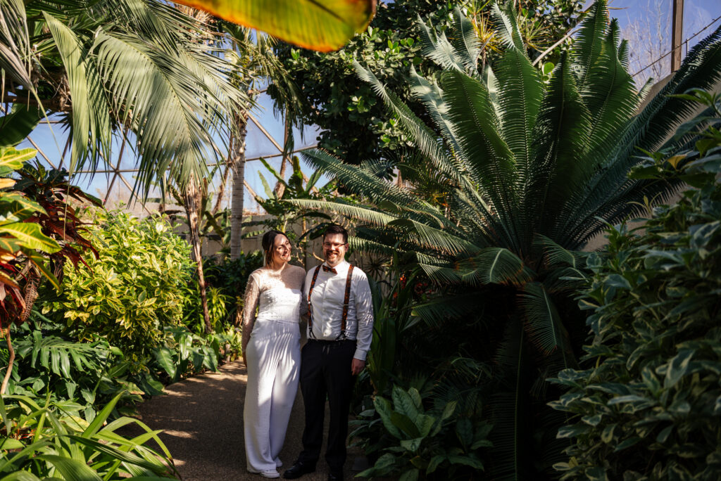 Photo of a winter elopement at the Botanical Garden in Des Moines, Iowa with a modern jumpsuit.