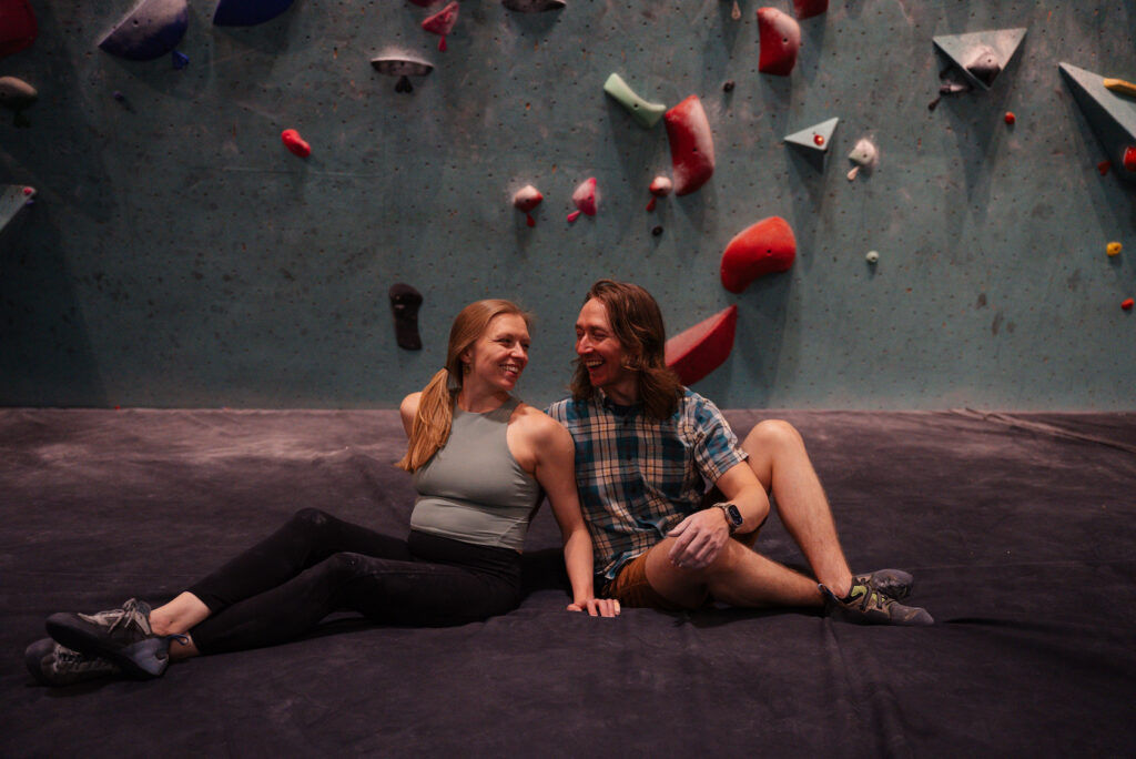 Minneapolis Bouldering Project engagement session with bouldering wall backdrop