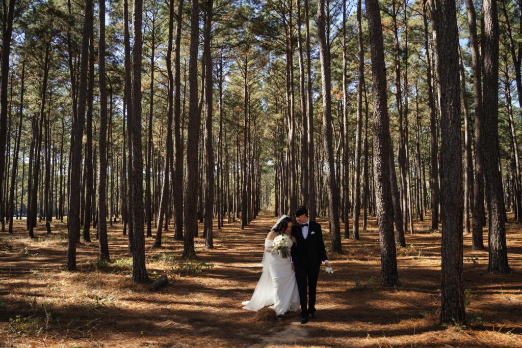 A queer couple walks through the woods during their elopement
